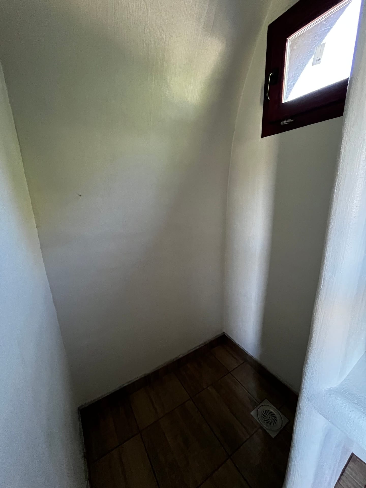Zaobljena tuš-kabina sa malim prozorom u kupatilu Čarobne kolibe
